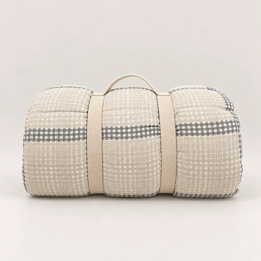 Couette de mi-saison avec poignée pratique pour le rangement, montrant sa face principale à carreaux beige et gris.