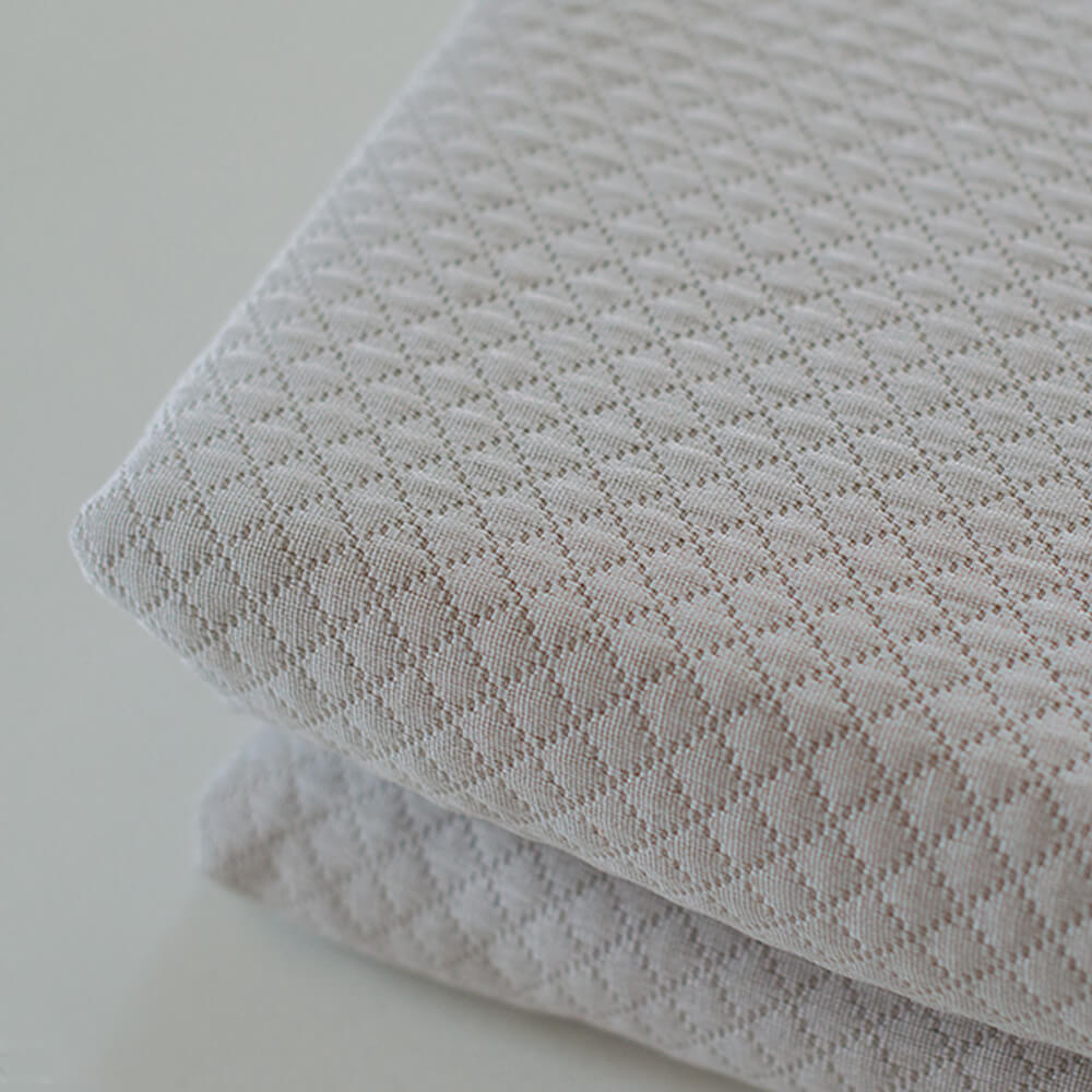 Geometric patchwork quilt with thin padding. Beige.