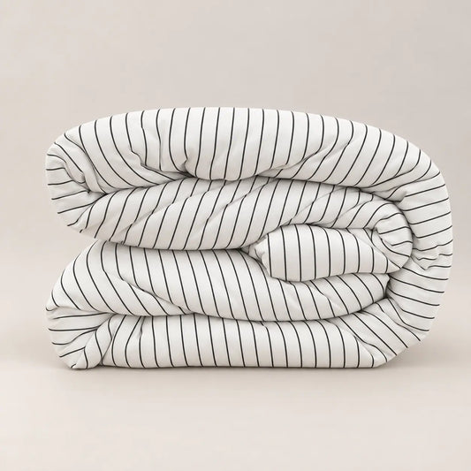 Vue de profil de la couette premium, mettant en valeur son garnissage de 250 g/m² et le contraste subtil entre les fines rayures et le dos blanc uni.